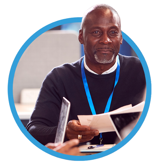 man smiling sitting at table wearing lanyard